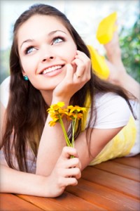 Girl lounges and reveals the cosmetic tooth veneers she received at Blaisdell Family Dentistry near Meridian, ID.