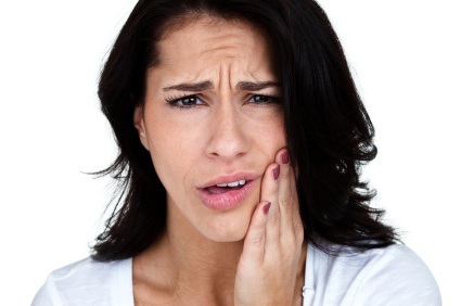 A woman grabbing her jaw in need of a root canal in Boise.